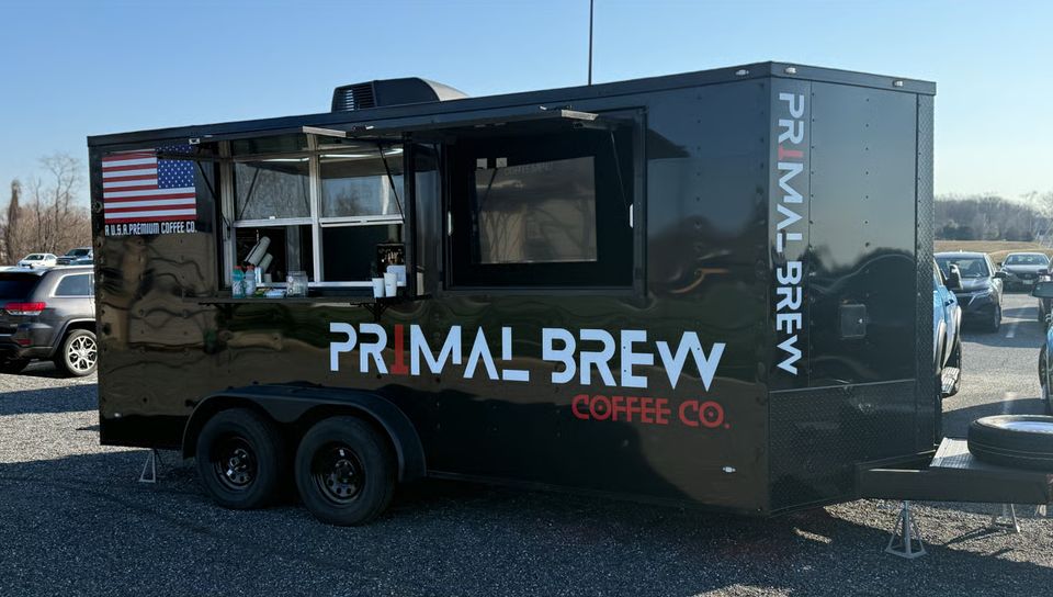 The black Primal Brew Coffee Co. espresso trailer parked and ready to serve